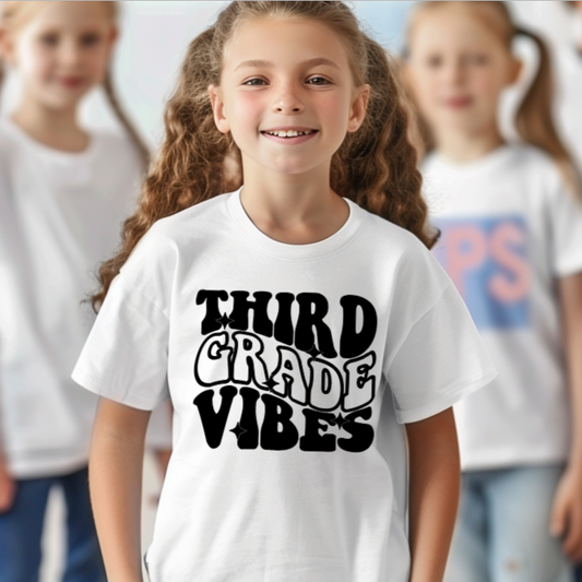 Child wearing a white t-shirt with 'Third Grade Vibes' text, standing in front of a group of children.